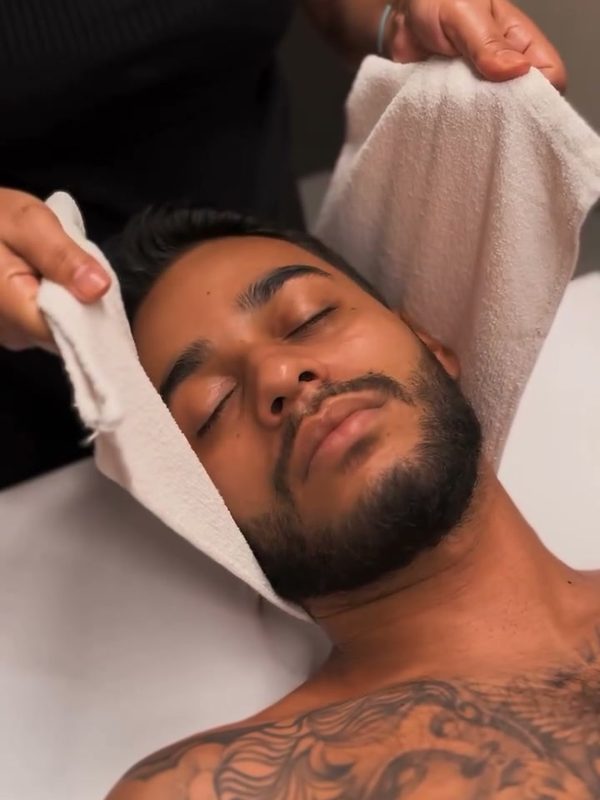 Cliente relaxando com toalha quente durante a massagem