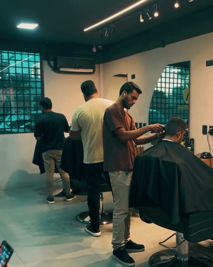 Barbeiros atendendo no salão da Bravo
