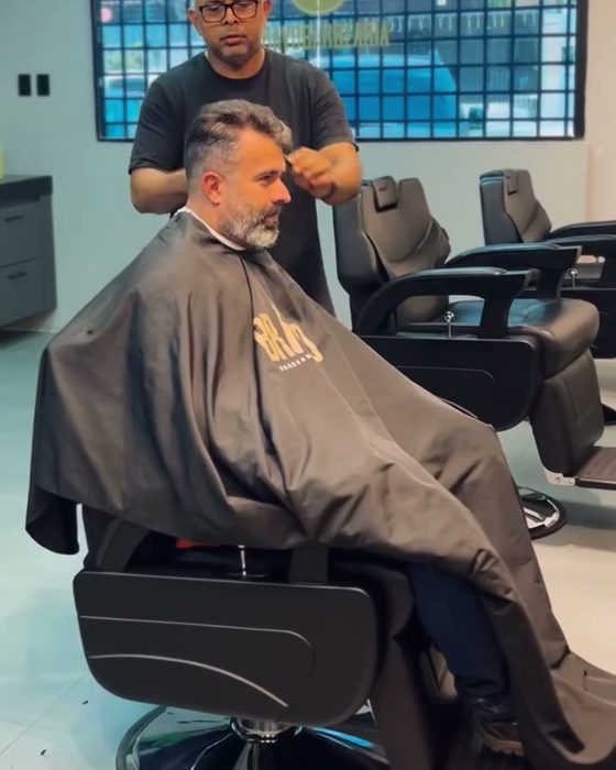 Barbeiro atendendo cliente no salão