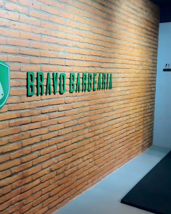 Parede de tijolo com o nome Bravo Barbearia