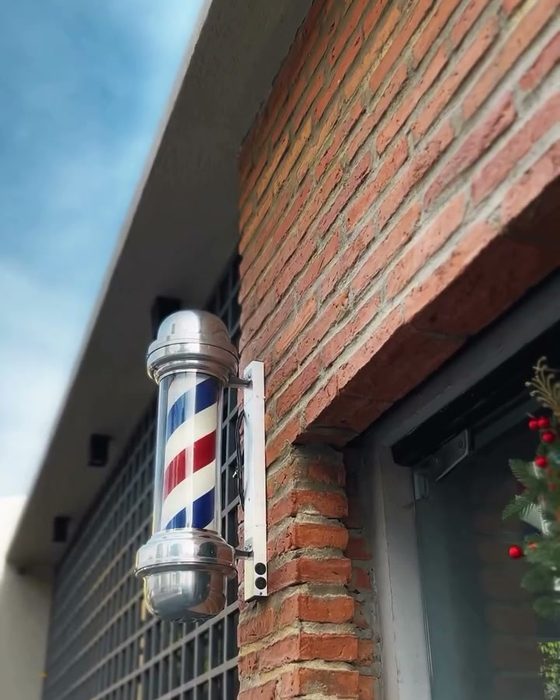 Poste de barbeiro na fachada de tijolo