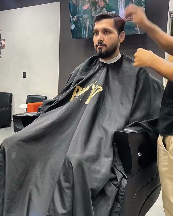 Cliente na cadeira com a TV ao fundo